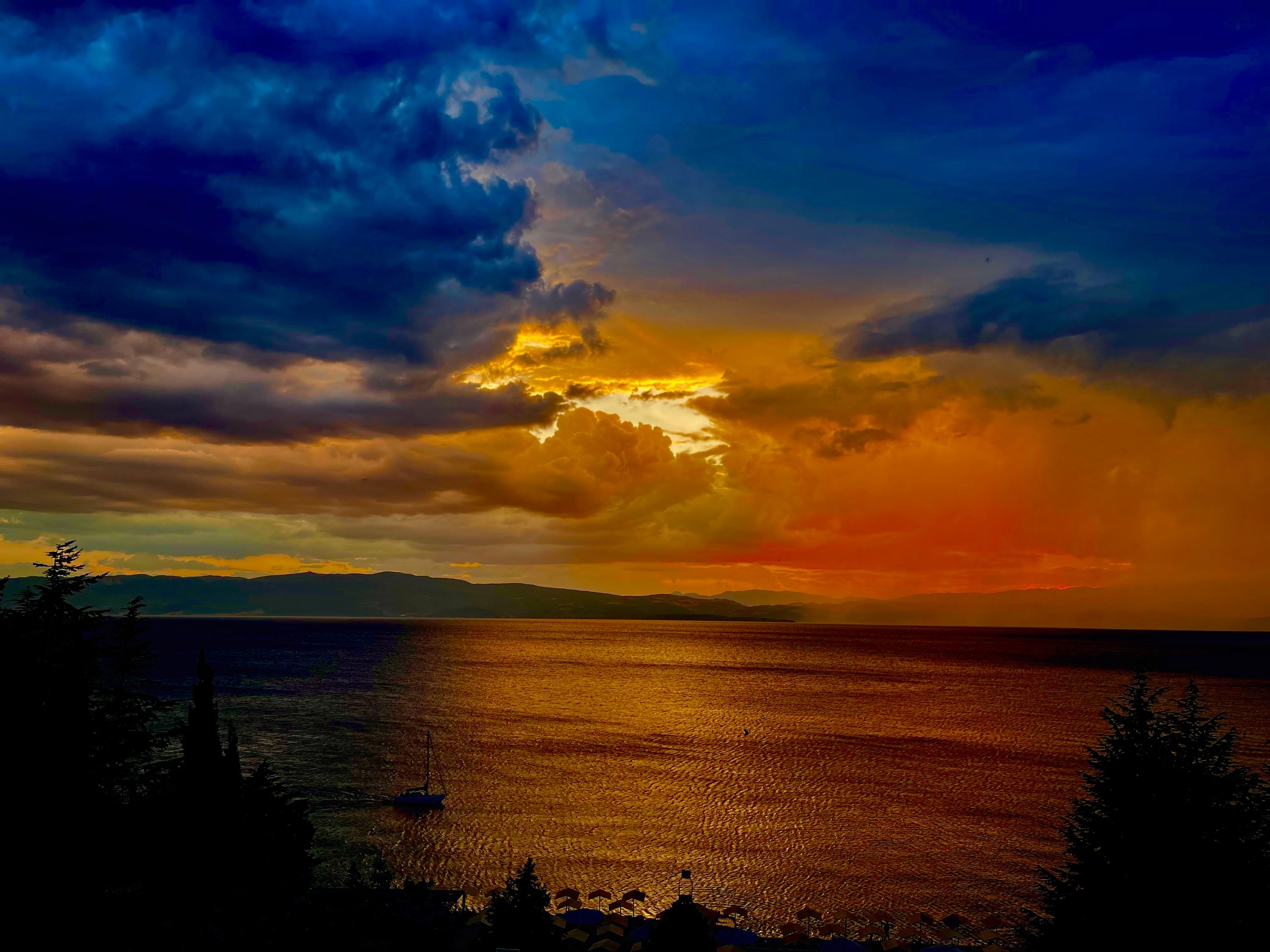 Coucher de soleil sur l'eau, ciel coloré, lumière douce.