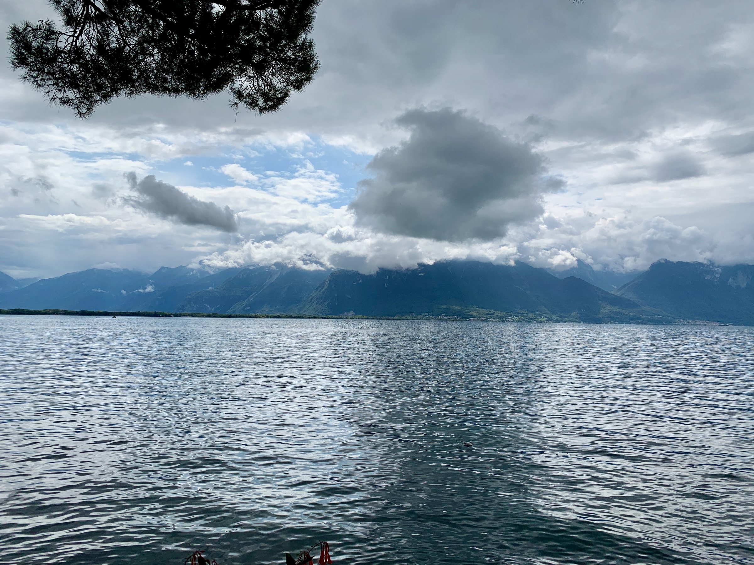 Lac face aux collines sous un ciel couvert.